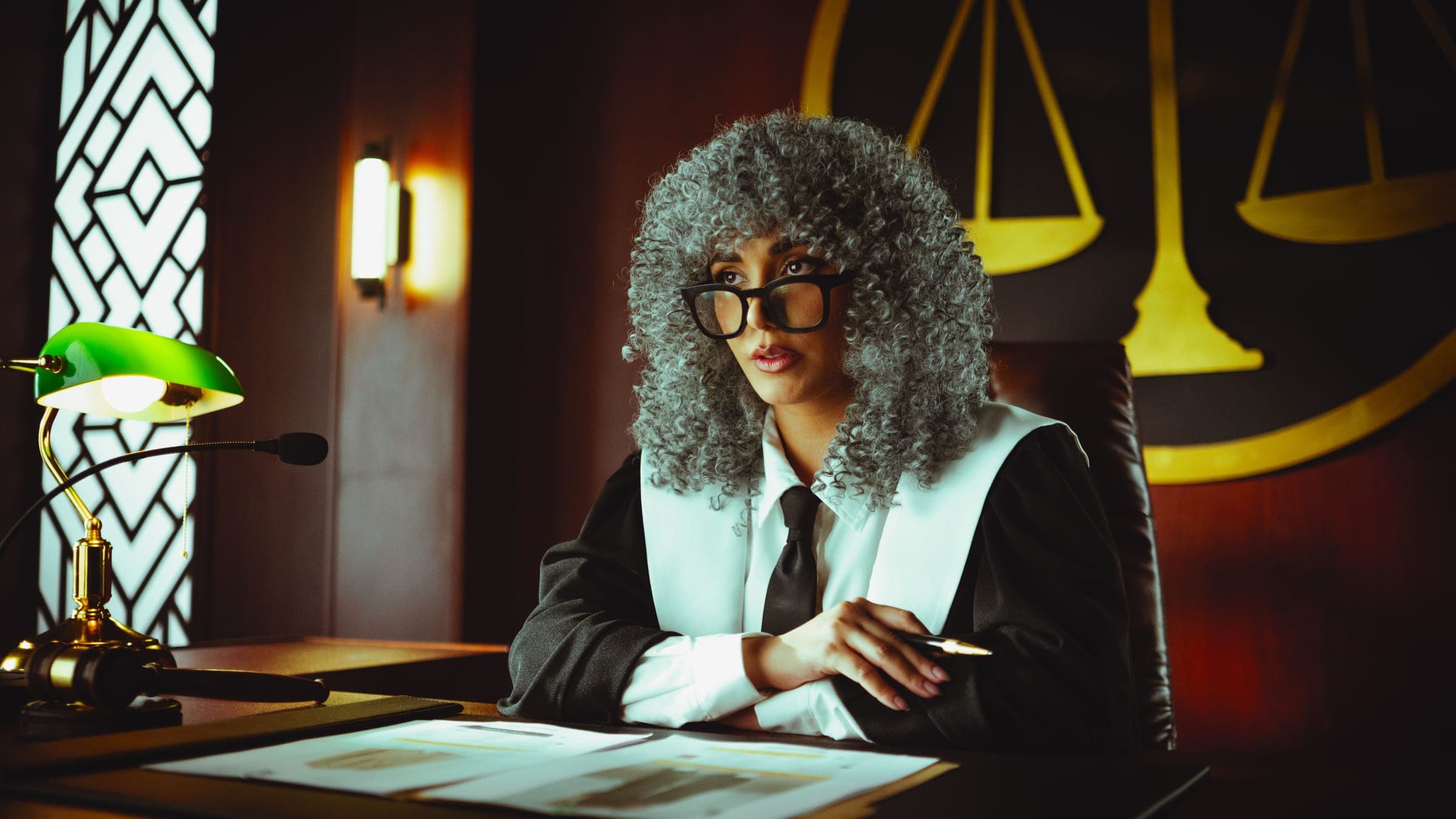 A judge in robes and wig at her bench