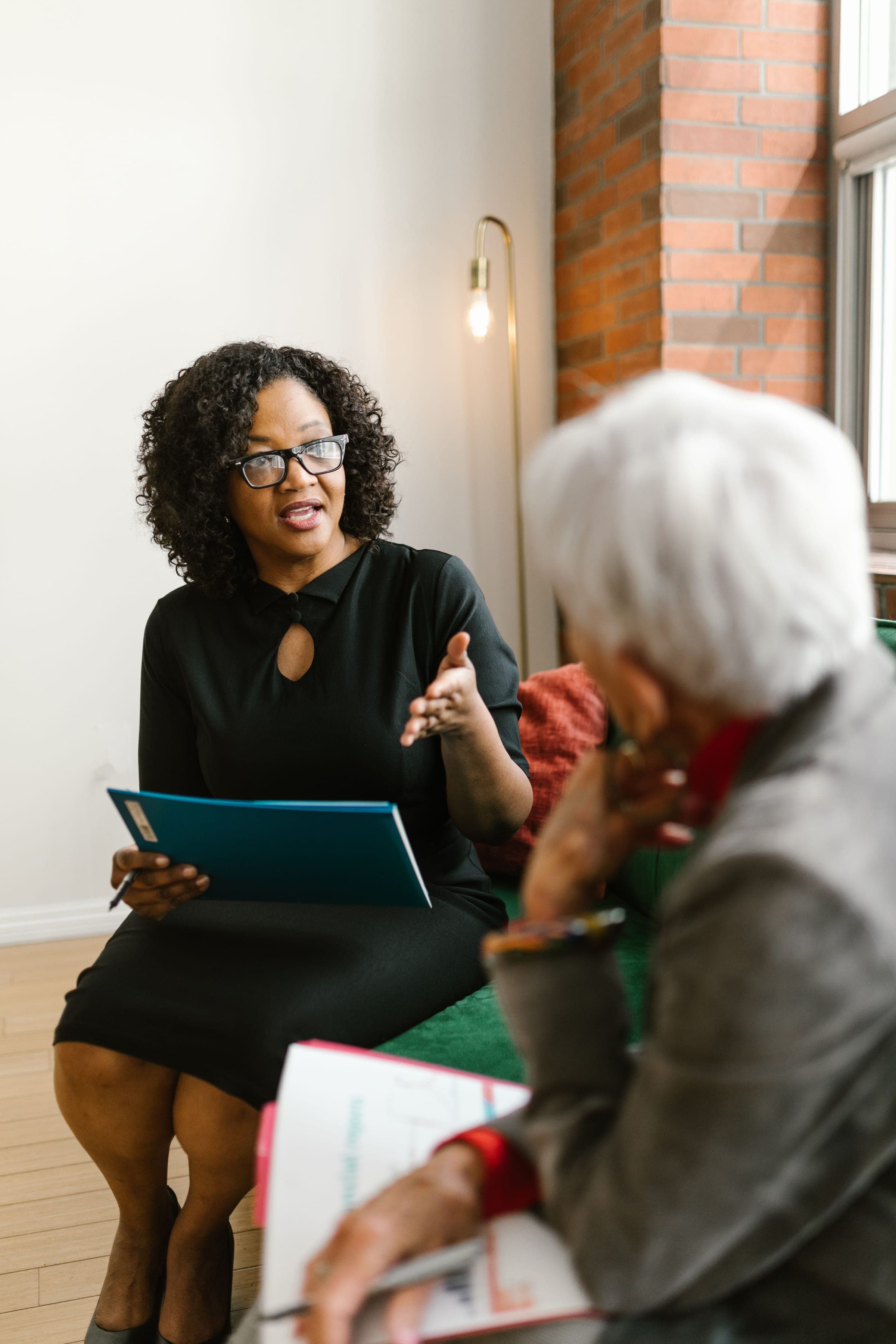 A lawyer with a folder talking a client through her options